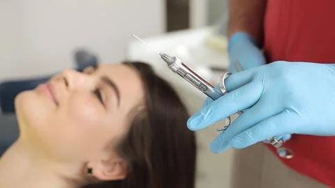 Dentist holding a syringe and anesthetizing his patient. Close up. Stock Photos