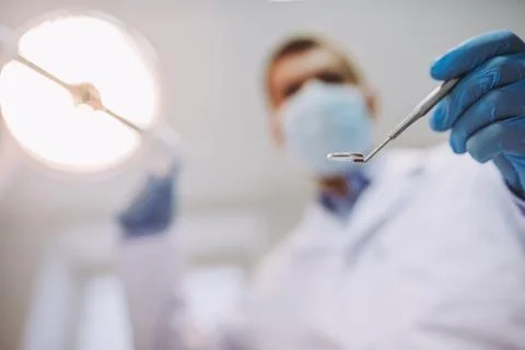 Dentist holding teeth mirror Stock Photos
