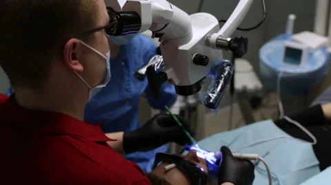Dentist looking into a microscope. Treats tooth Stock Footage 58549984