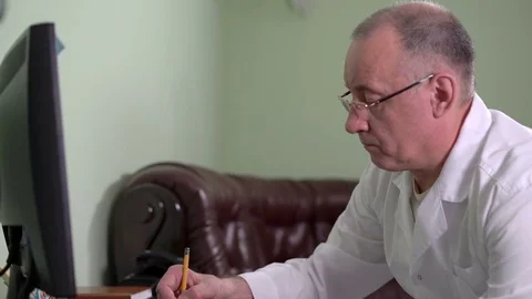 Dentist Make Notes in a Notebook With a Pencil Examining X-Ray of the Tooth Stock Footage 77067236