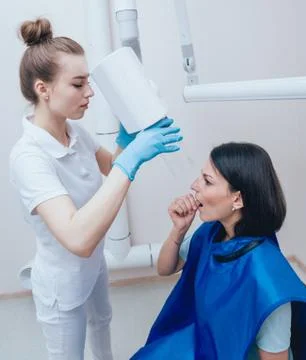 Dentist make x-ray image for young woman in dental clinic. Stock Photos