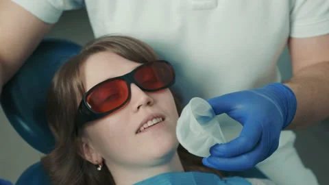 Dentist makes a procedure for teeth whitening. Beautiful smile. Ultraviolet lamp Stock Footage 154118213