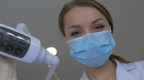 Dentist in Mask is Holding a Hook Mirror Smiling Standing Upon a Patient Turns Stock Footage 60973517
