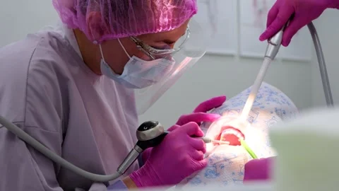 A dentist performing professional teeth cleaning for a young woman Stock Footage 314556834