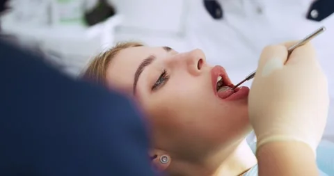 The dentist performs an examination using a dental mirror a woman Stock Footage 165450561