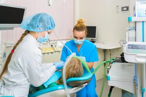 Dentist performs a procedure of care for teeth child with deep anesthesia Stock Photos
