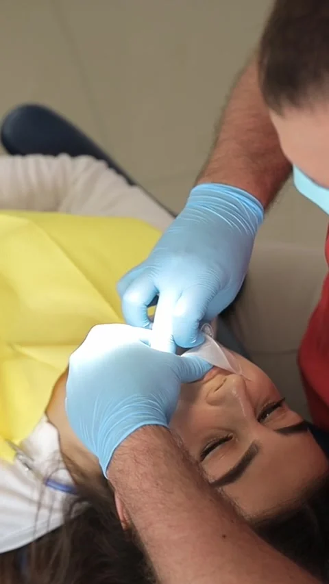 The dentist performs teeth whitening using modern methods. Vertical video Stock-Footage 250384872
