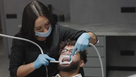 Dentist performs tooth cleaning and treatment on patient in dental office Video stock 331515478