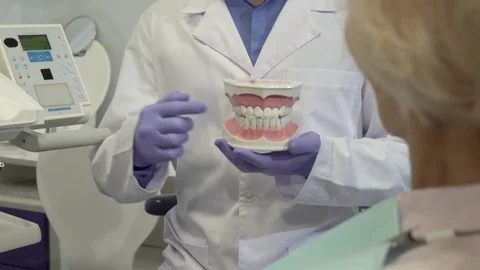 Dentist points his fingers on lower teeth on layout Stock Footage 73676236