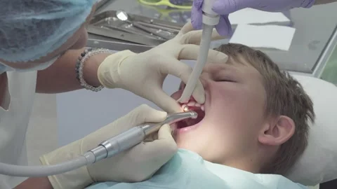 Dentist polishes broken tooth surface of boy in dental clinic Stock Footage 330482571