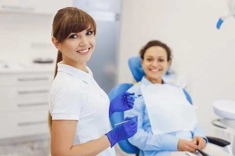 Dentist posing at camera with dental tools in hands Stock Photos
