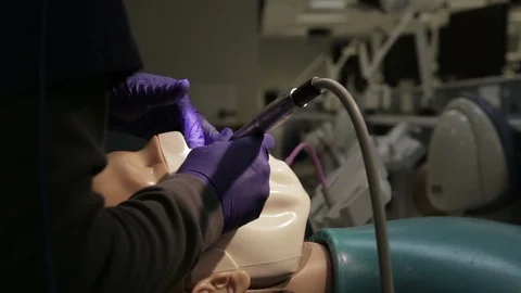 Dentist Practicing By Drilling on a Mannequin Stock Footage 106163936