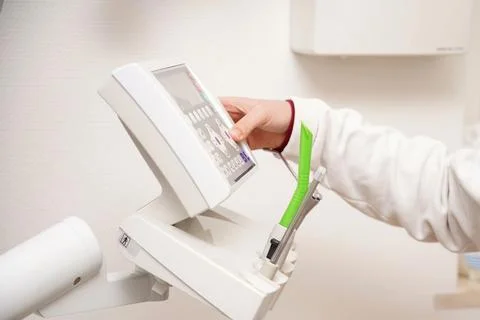 The dentist prepares for work and sets up the remote control for examining te Stock Photos