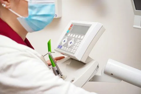 The dentist prepares for work and sets up the remote control for examining te 스톡 사진
