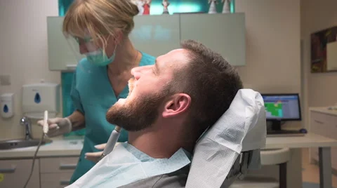 Dentist preparing dental instruments and talking with patient. Steadicam. Vidéo 68521681