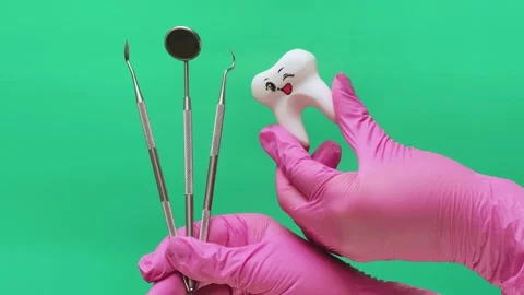 Dentist Presenting Dental Instruments and Smiling Tooth Model Stock Footage 337106414