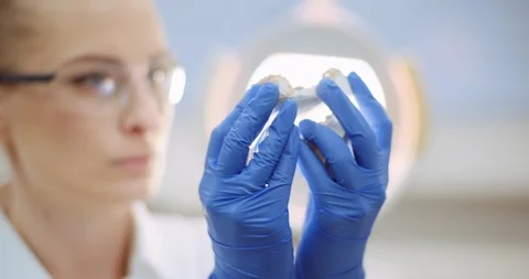 Dentist prosthetics looking at denture or jaw cast Stock Footage 125490953