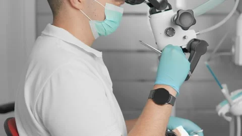 Dentist in protective mask and gloves performing dental examination using modern Stock Footage 341034764