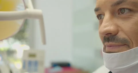 The dentist pulls on the mask close up. Caucasian Arabic appearance Stock Footage 136960134