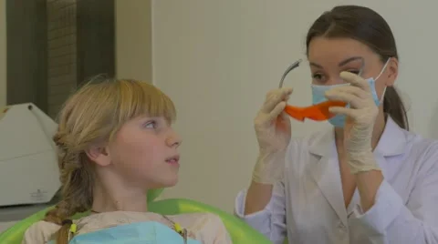 Dentist Puts a Glasses on Using uv Dental Lamp Patient Girl Doctor in Mask is Stock Footage 60981330