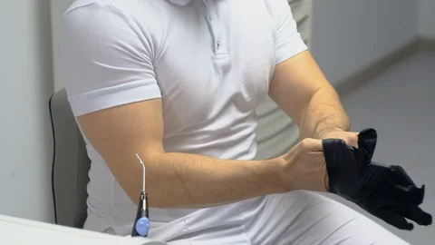 Dentist puts on gloves before surgery Vidéo 124577237