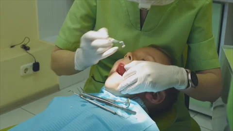 Dentist putting seal teeth to a small patient in dental clinic Video stock 152104653