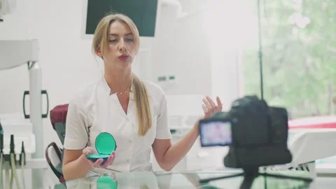 A dentist records a video explaining information about Invisalign braces, clear  Vidéo 241020984