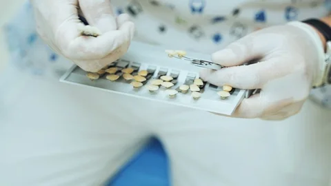 The dentist selects the right shade of the tooth on a Vitascale. Stock Footage 119174620