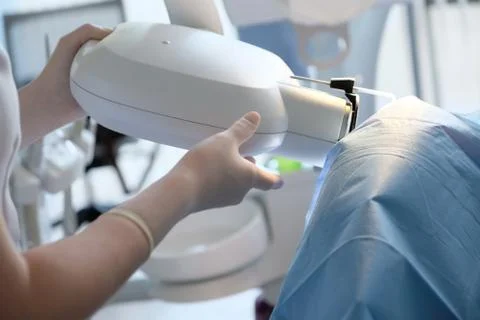 The dentist sets up an X-ray machine for a control photograph of the patient' Stock Photos
