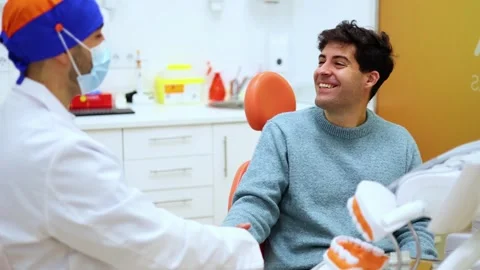 Dentist shaking hands with patient after checkup Stock Footage 295784558