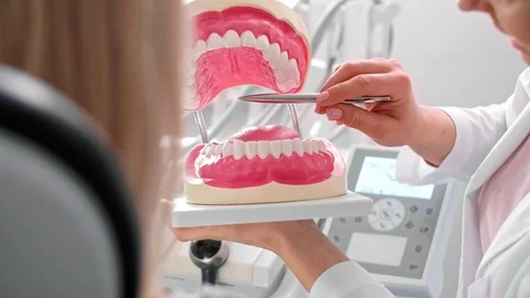 Dentist showing patient the artificial dentures Stock Footage 106976833
