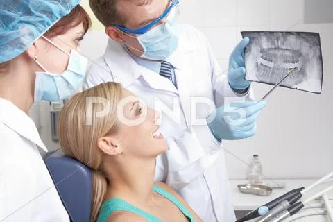 A dentist showing a patient her teeth x-ray Stock Photos