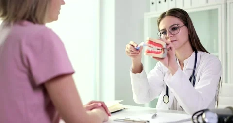 Dentist shows model of jaw to properly care for teeth and oral cavity Stock Footage 233200385