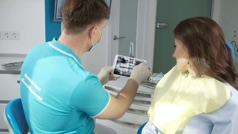 Dentist shows on the tablet x-ray her teeth. Stock Footage 74586724