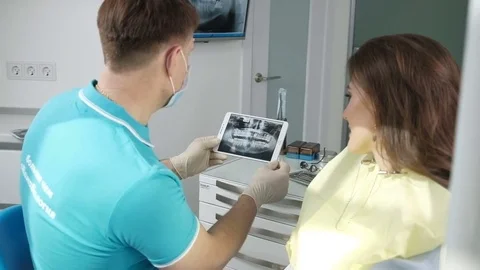 Dentist shows on the tablet x-ray her teeth. Stock Footage 74587009
