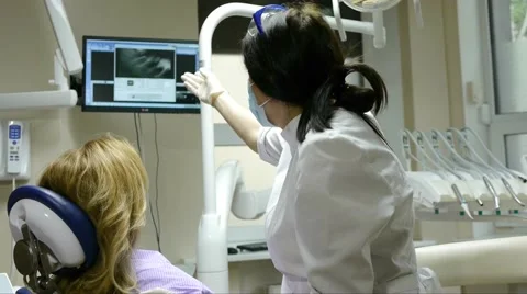 Dentist shows the X-ray image on the monitor of the tooth of the patient Stock Footage 66692893