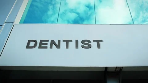 Dentist Sign on Modern Building with Cloud Reflection on Windows Glass Stock Footage 303556328
