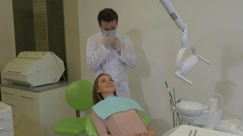 Dentist Sits Behind a Client Takes a Chair Down Examining a Teeth of a Patient Stock Footage 60975283