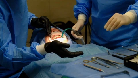 The dentist surgeon performs an implant placement operation Stock Footage 124574819