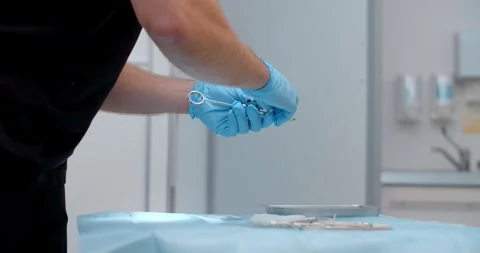 Dentist surgeon prepares the instruments before the operation in clinic Stock Footage 263221096