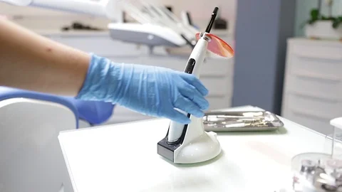 The dentist takes an ultraviolet lamp for polymerization Stock Footage 120640778