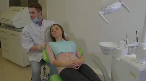Dentist is Talking to a Client Friendly Young Woman is Smiling Lying on a Chair Stock Footage 61001417