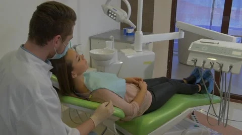 Dentist is Talking to a Client Gives Her a Mirror Woman is Smiling Looking at Stock Footage 60975026