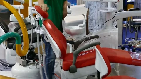 The dentist is talking to the man in the office. Red dental chair close-up Stock-Footage 73669546