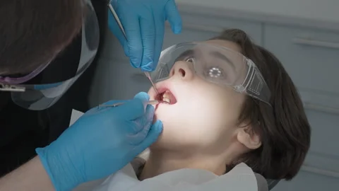 Dentist testing local anesthesia effect on boy gum using dental elevator 스톡 동영상 330294631