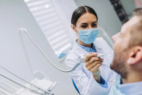 Dentist treating patient teeth Stock Photos