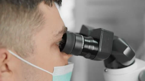 The dentist uses a microscope to accurately diagnose and treat the problem. The Stock Footage 250125598