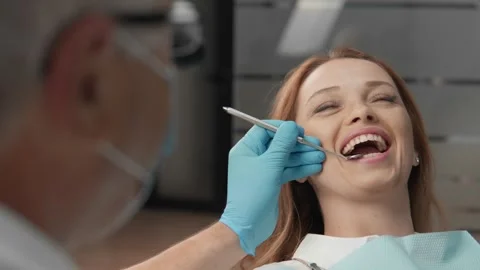 The dentist uses specialized instruments to examine the patient's mouth. The Stock Footage 250125474