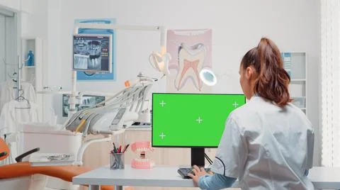 Dentist using computer with horizontal green screen on display Foto stock