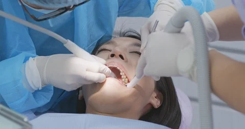 Dentist using dental drill on patient teeth Stock Footage 86553359